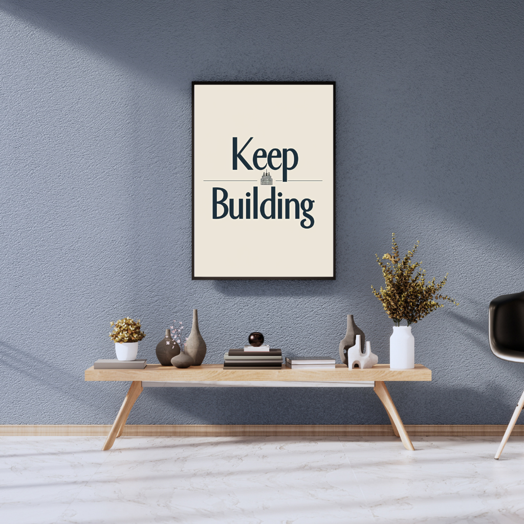 Grå typografiposter från Nordanio med texten "Keep Building" i tredimensionellt design, inramad och dekorativ väggkonst.