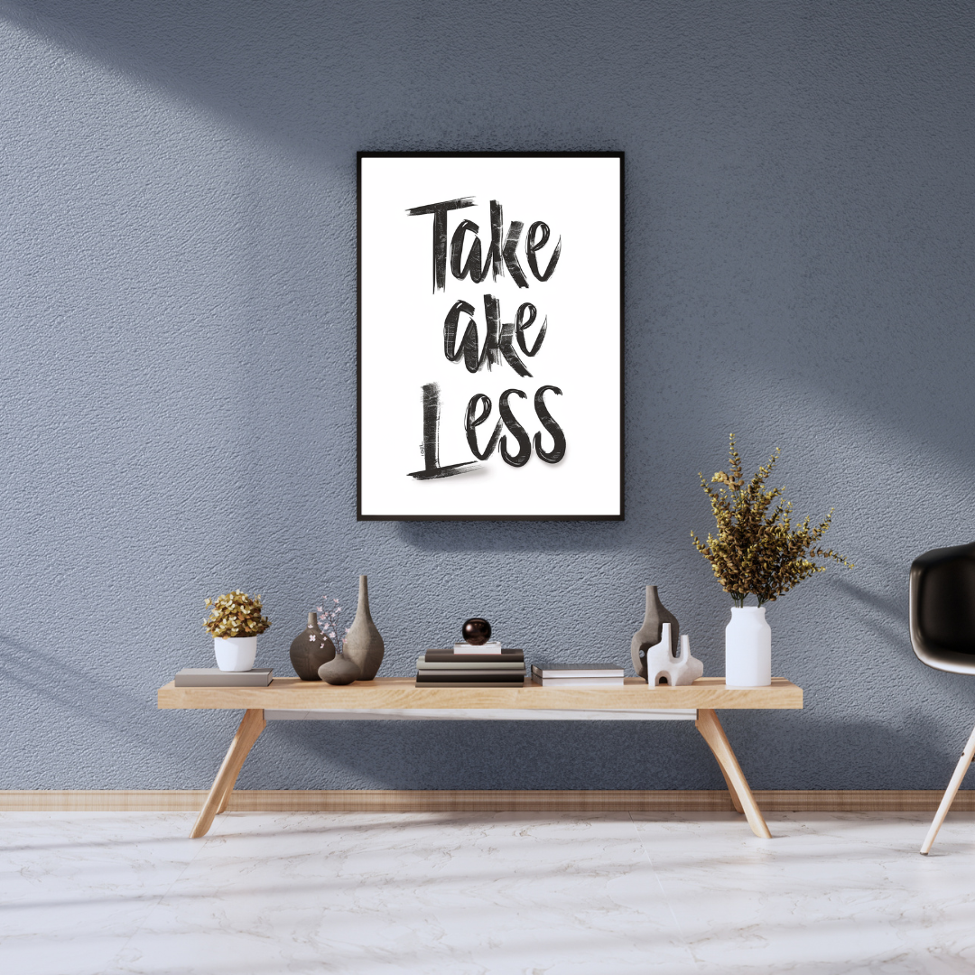 Grå typografiposter "Take Less" av Nordanio i ett 3D-ram, väggkonst för modern inredning, syns på en vägg.